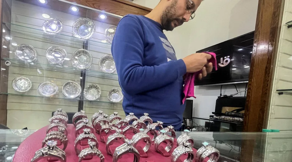 بائع ينظّف خواتم من الفضة في متجره (رويترز)