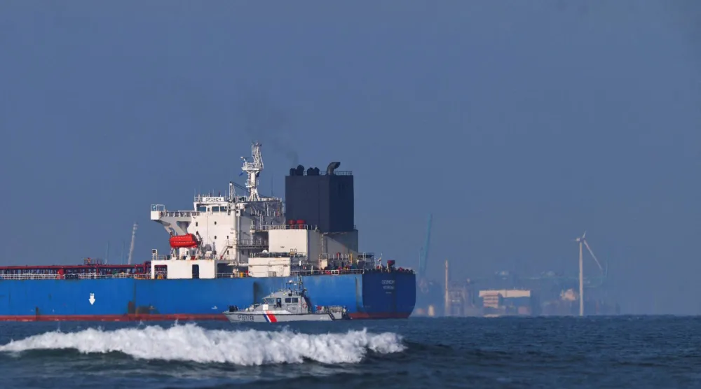 قارب تابع للبحرية الفرنسية يحيط بناقلة النفط «غرينش» التي اعترضتها فرنسا في بحر البوران (رويترز)