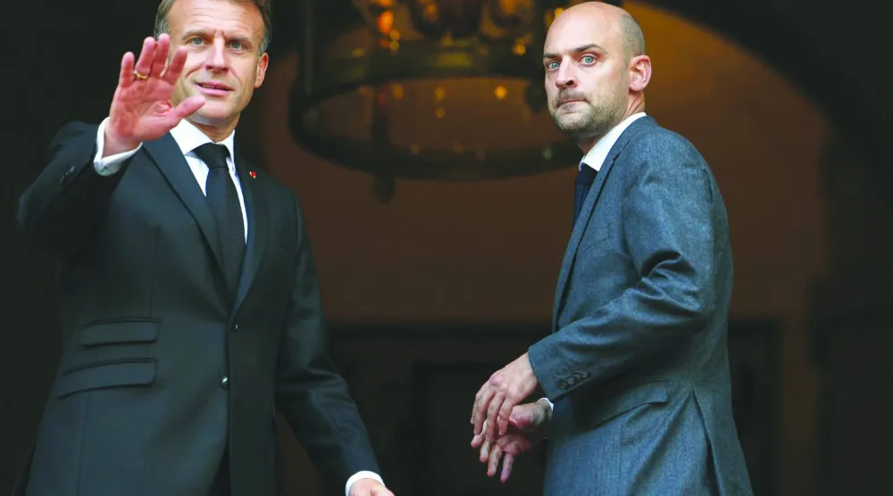 وزير الخارجية الفرنسي جان نويل بارو مستقبلاً الرئيس ماكرون على مدخل وزارته (أ.ب)