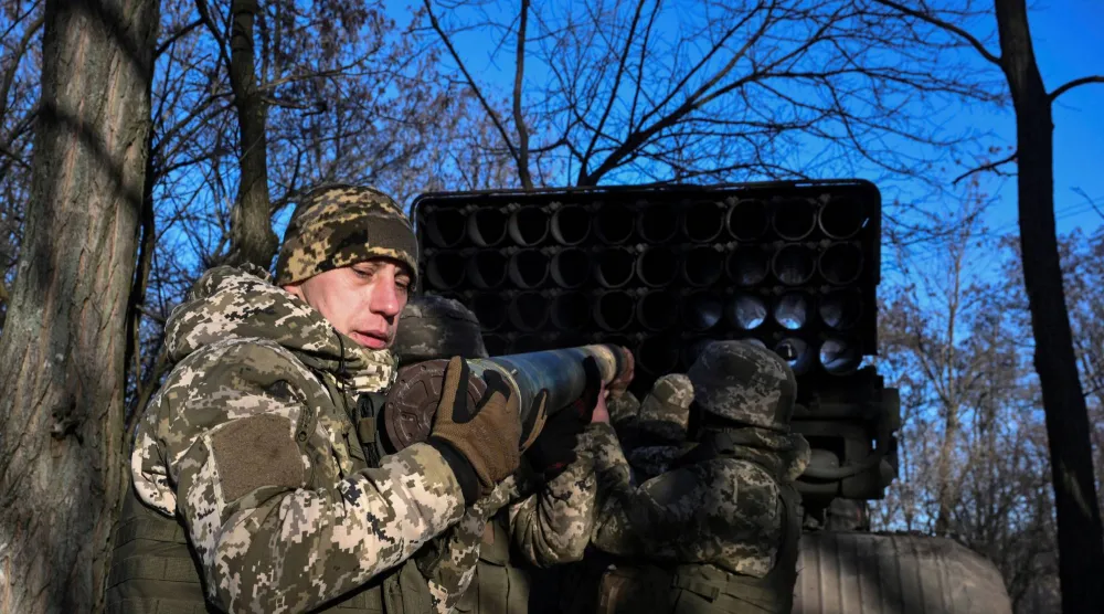 جنود أوكرانيون يذخرون راجمة صواريخ من عيار 122 ملم ف دونيتسك (رويترز)