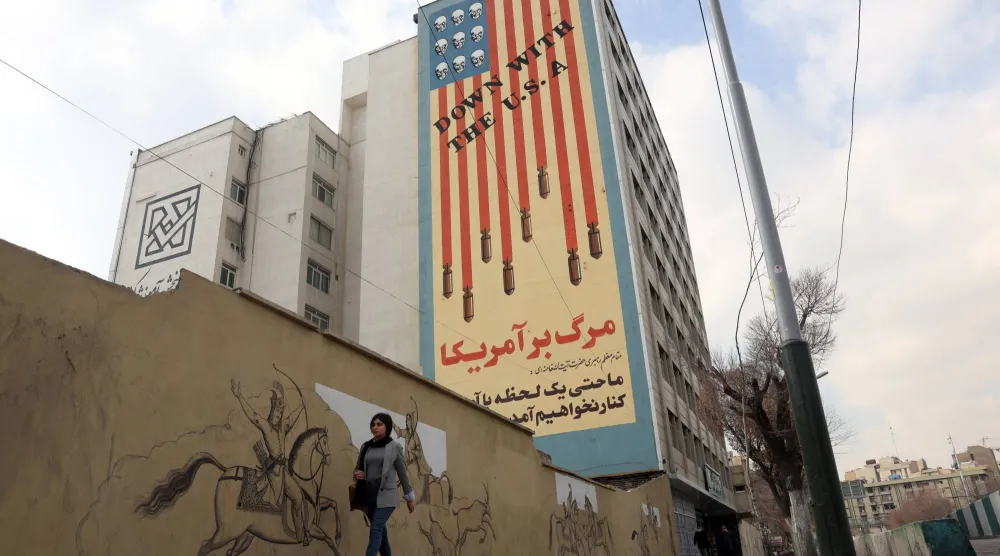 إيرانية تسير بجانب جدارية مناهضة للولايات المتحدة في طهران (إ.ب.أ)