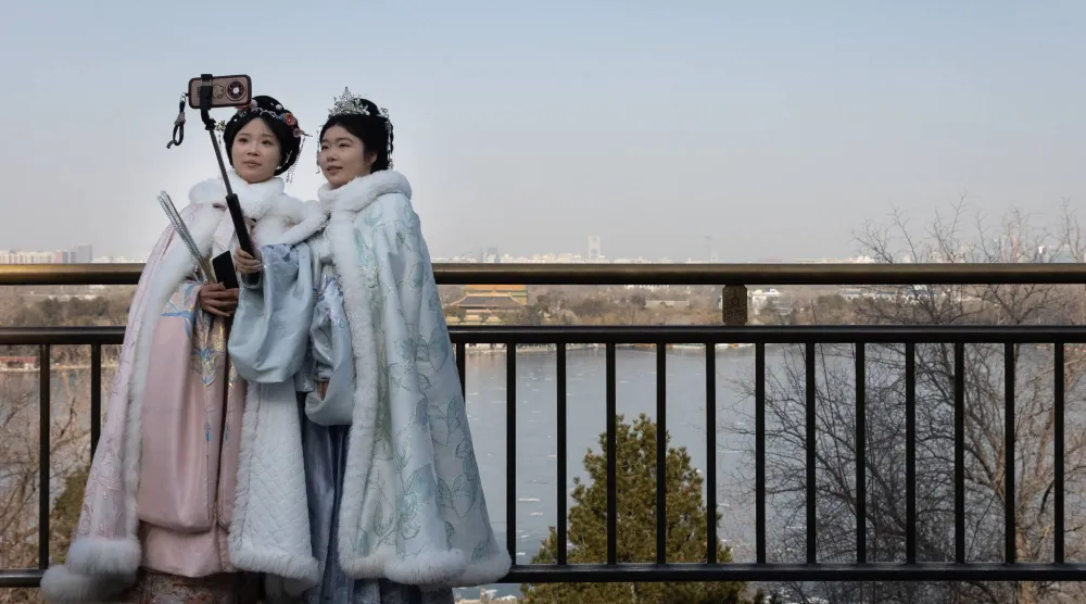 مواطنون يرتدون زياً تقليدياً ويلتقطون صوراً تذكارية في إحدى الحدائق بالعاصمة الصينية بكين (إ.ب.أ)