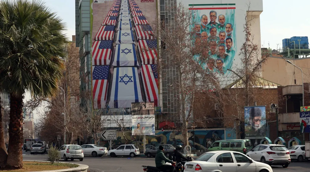 لوحة دعائية مناهضة للولايات المتحدة وإسرائيل على مبنى التنسيق الإيراني - الفلسطيني وسط طهران (إ.ب.أ)