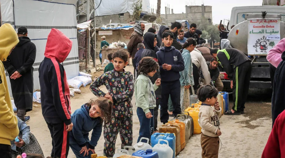 فلسطينيون يصطفون للحصول على الماي في مخيم المصيرات بقطاع غزة. (أ.ف.ب)