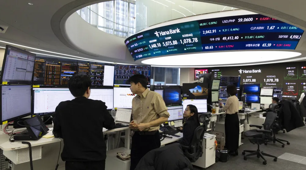 متداولون كوريون جنوبيون يعملون أمام شاشات في بنك هانا في سيول (إ.ب.أ)