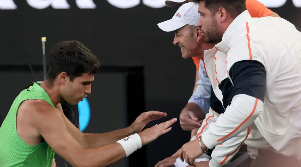 الإسباني كارلوس ألكاراس يحتفل مع جهازه الفني بعد فوزه على الألماني ألكسندر زفيريف في نصف نهائي فردي الرجال ببطولة «أستراليا المفتوحة» (أ.ف.ب)