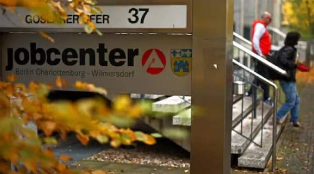 أشخاص يسيرون خارج مركز توظيف في برلين (رويترز)