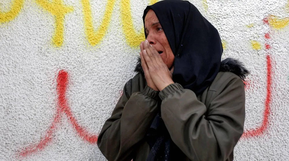 فلسطينية تبكي خارج «مستشفى الشفاء» حيث يجري الخبراء الجنائيون فحصاً لجثث فلسطينيين أعادتها إسرائيل بموجب اتفاق وقف النار في غزة الجمعة (أ.ف.ب)