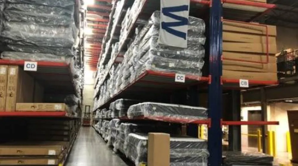 عمال مستودعات «إيه بي تي» للإلكترونيات يتعاملون مع مخزون بمنشأتهم بغلينفيو في إلينوي (رويترز)