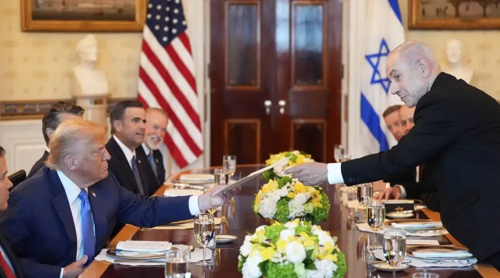 رئيس الوزراء الإسرائيلي بنيامين نتنياهو يسلّم الرئيس الأميركي دونالد ترمب ملفاً خلال اجتماع في البيت الأبيض بواشنطن يوم 7 يوليو 2025 (أ.ب)