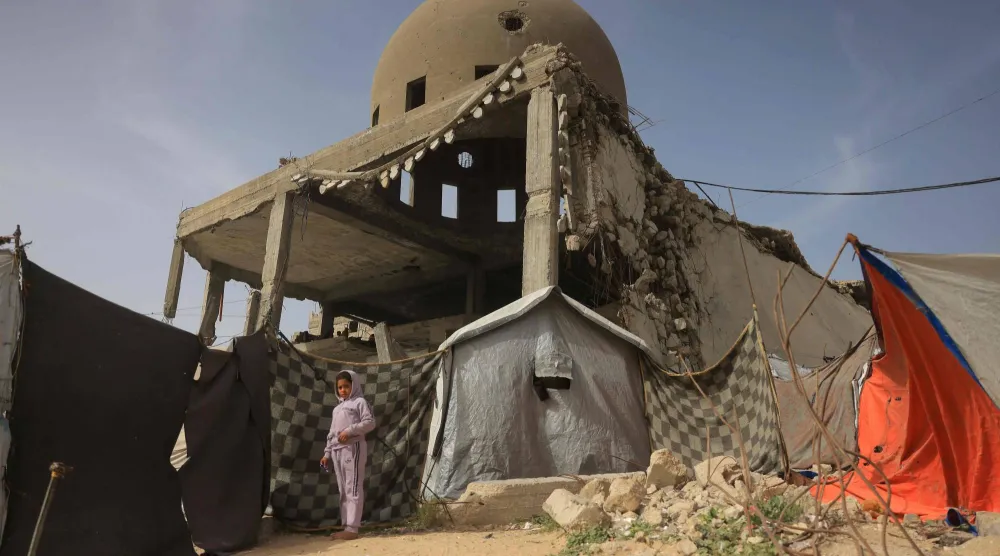 طفلة بجانب مدمر جراء الضربات الإسرائيلية في خان يونس (أ.ف.ب)