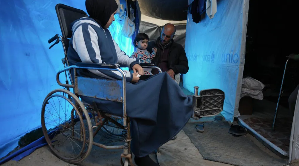 إسلام صالح التي أصيبت في ساقها اليسرى أثناء غارة إسرائيلية على ملجأ مدرسي بجباليا عام 2024 تجلس على كرسي متحرك داخل خيمة عائلتها في زويدة بقطاع غزة (أ.ب)