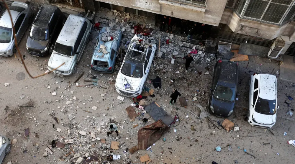 Filistinliler, bugün İsrail’in Gazze kentine düzenlediği saldırının ardından hedef alınan noktayı inceliyor. (Reuters)