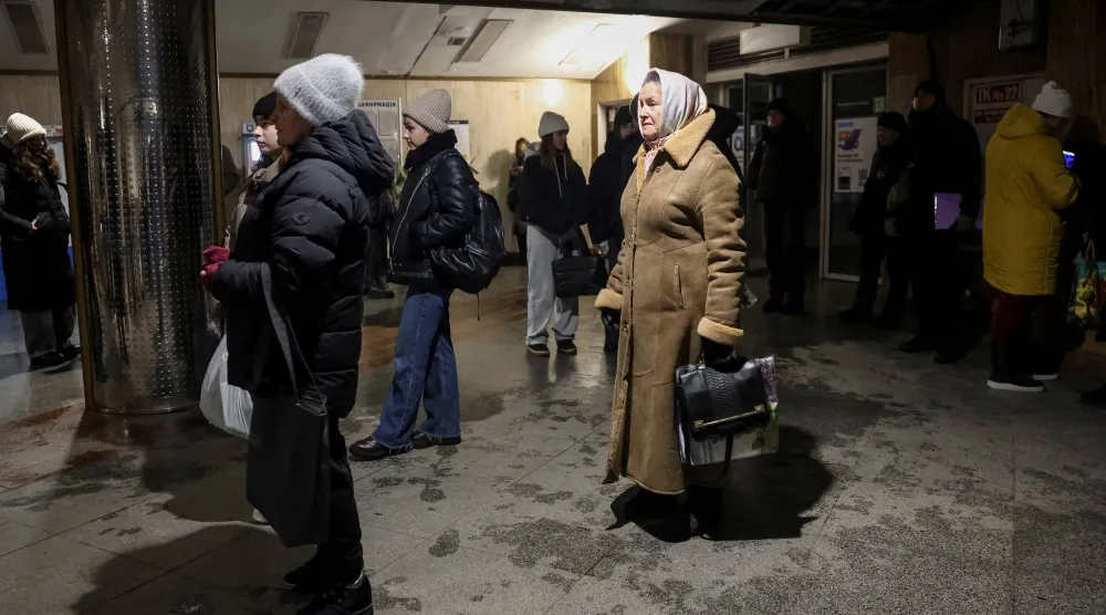 أوكرانيون عند مدخل محطة لقطارات الأنفاق في كييف بعد توقفها عن العمل (رويترز)