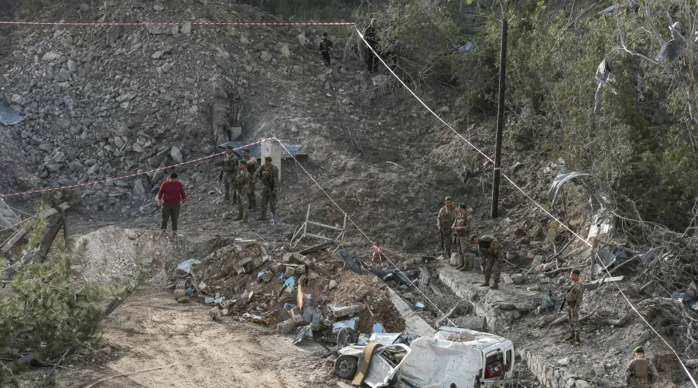 جنود لبنانيون يتفقدون موقع الحادث عقب غارة جوية إسرائيلية استهدفت مبنى في قرية كفر دونين جنوب البلاد (أ.ف.ب)