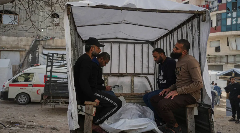 فلسطينيون ينقلون أحد ضحايا القصف الإسرائيلي على مقر للشرطة في قطاع غزة إلى مستشفى الشفاء (أ.ب) 