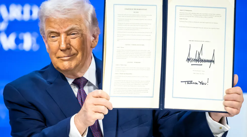 President Donald Trump, center, holds up a signed Board of Peace charter during the Annual Meeting of the World Economic Forum in Davos, Switzerland, Thursday, Jan. 22, 2026. (Gian Ehrenzeller/Keystone via AP)