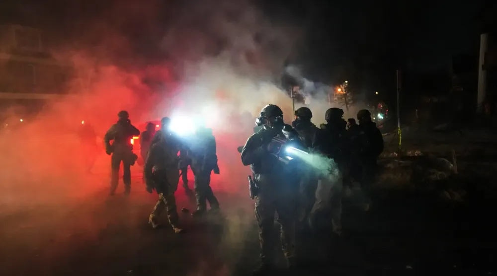 Minneapolis'te meydana gelen silahlı saldırı olayının ardından, güvenlik güçleri göz yaşartıcı gazın ortasında bekliyor (Arşiv- AP)