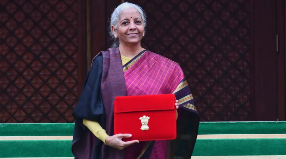وزيرة المالية الهندية نيرمالا سيثارامان تعرض ملفاً أحمر اللون يحتوي على الموازنة الاتحادية لعامي 2026 - 2027 على درجات مبنى البرلمان (أ.ب)