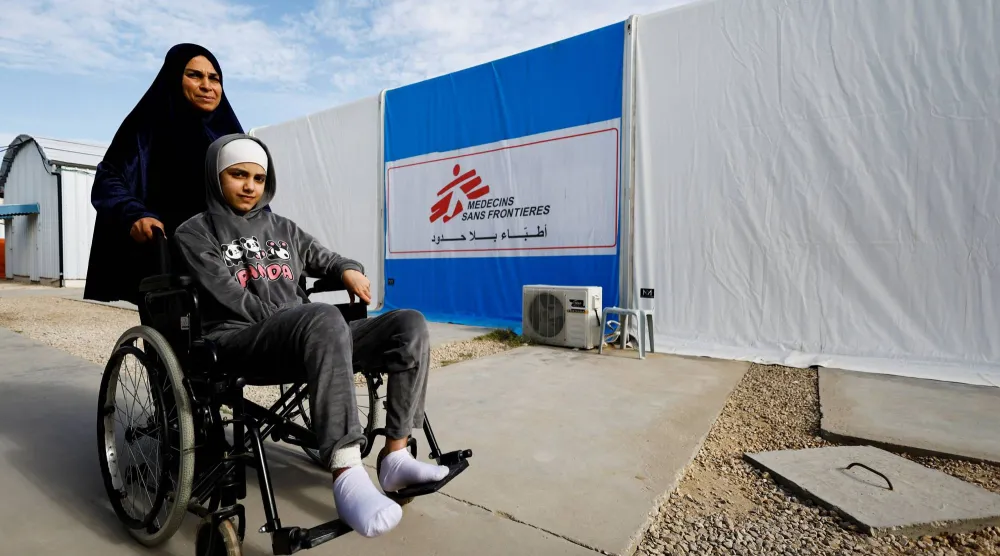 فلسطينية تساعد شابة مصابة بحروق بمستشفى تابع لمنظمة «أطباء بلا حدود» وسط نقص حاد في المعدات الطبية والأدوية والمواد الأساسية اللازمة لعلاج الحروق بمدينة زويدا وسط قطاع غزة (رويترز)