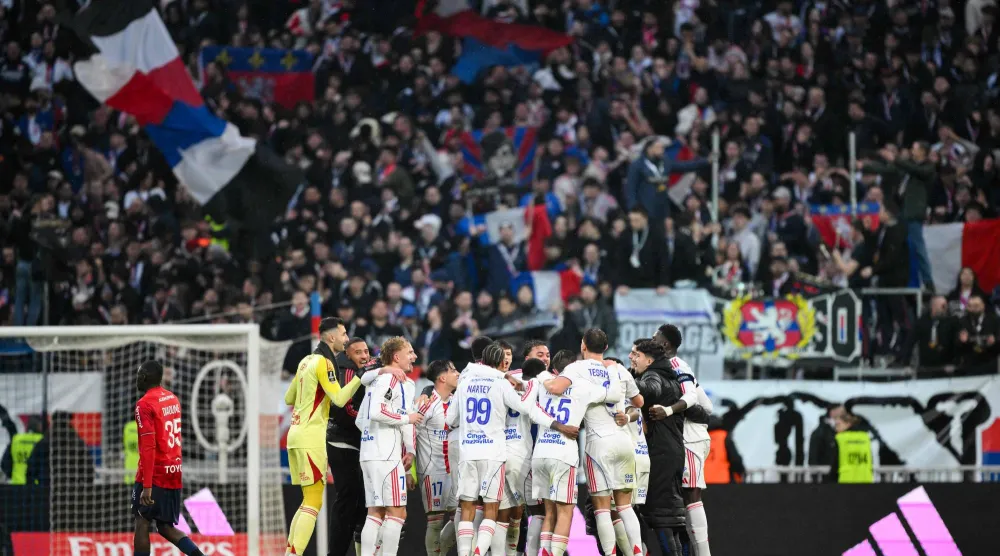 احتفالية لاعبي أولمبيك ليون مع جماهيرهم بهدف الفوز على ليل (أ.ف.ب)