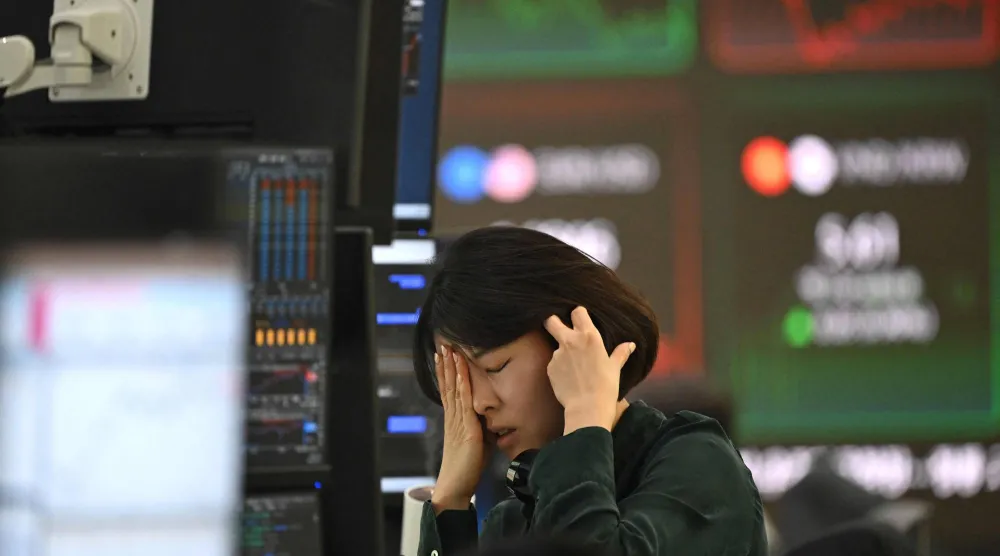 متداولة تتفاعل في سوق العملات أثناء متابعتها لأسعار الصرف بالمقر الرئيسي لبنك هانا في سيول (أ.ف.ب)