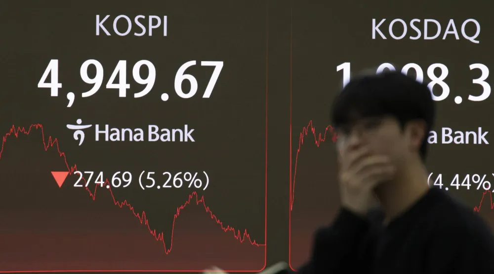 متداول كوري جنوبي يقف متأثراً أمام شاشة مراقبة مؤشر «كوسبي» في بنك هانا بسيول (إ.ب.أ)