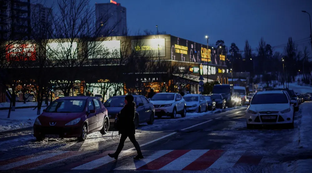 أحد المشاة يعبر طريقاً في يوم شتوي بالعاصمة الأوكرانية كييف وسط استمرار الهجمات الروسية على البنية التحتية للبلاد 30 يناير 2026 (رويترز)