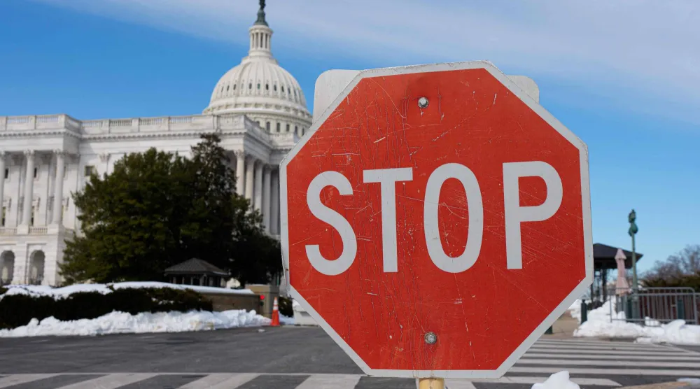 تظهر لافتة توقف وسط بقع من الثلج أمام مبنى الكابيتول الأميركي في واشنطن العاصمة في 31 يناير2026 (أ.ف.ب)