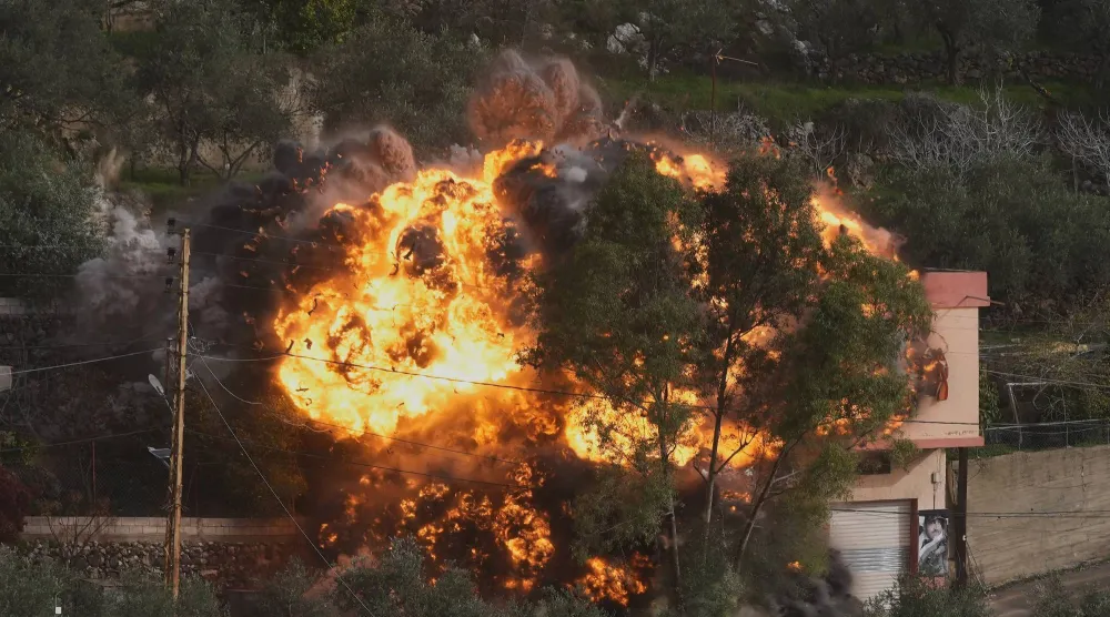 ألسنة لهب تتصاعد جراء استهداف إسرائيلي لمنزل في بلدة عين قانا بجنوب لبنان بعد إنذار بإخلائه (أ.ب)