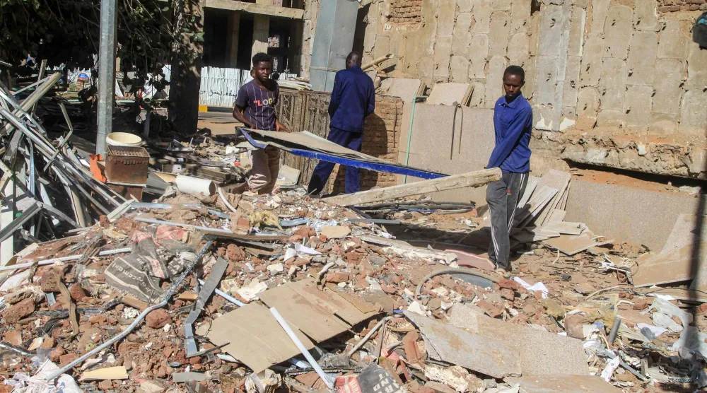 عمال يزيلون ركاماً في مساعٍ لاستعادة البنية التحتية بالعاصمة السودانية الخرطوم في 11 يناير 2026 (أ.ف.ب)