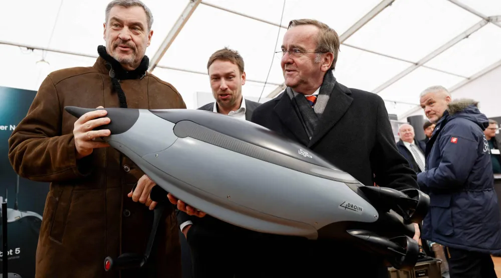 وزير الدفاع الألماني بوريس بيستوريوس (يمين) يفحص غواصة مسيرة خلال زيارته مركزاً للابتكار تابعاً للجيش الألماني في منطقة إردينغ بالقرب من مدينة ميونيخ جنوبي ألمانيا (أ.ف.ب)