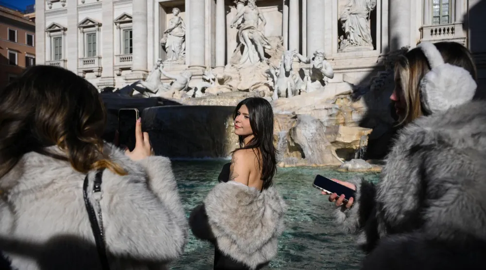 امرأة تتخذ وضعية تصوير عند حوض نافورة «تريفي» في اليوم الأول من الدخول المدفوع إلى هذا المعلم السياحي في روما... إيطاليا 2 فبراير 2026 (إ.ب.أ)