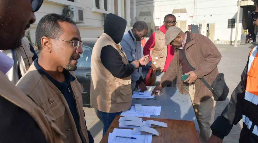 سودانيون يبحثون عن أسمائهم في قائمة المسافرين ضمن الرحلة 43 لقطارات العودة (رئاسة مجلس الوزراء المصري)