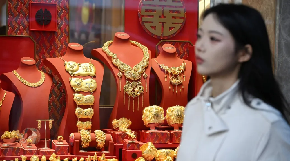 امرأة تمر أمام متجر لبيع الذهب في هونغ كونغ (أ.ف.ب)