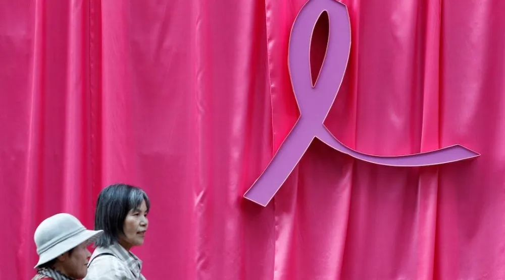 Visitors walk past a sculpture of a pink ribbon installed to promote the "Pink Ribbon" breast cancer awareness campaign in this illustration, October 5, 2011. (Reuters) 