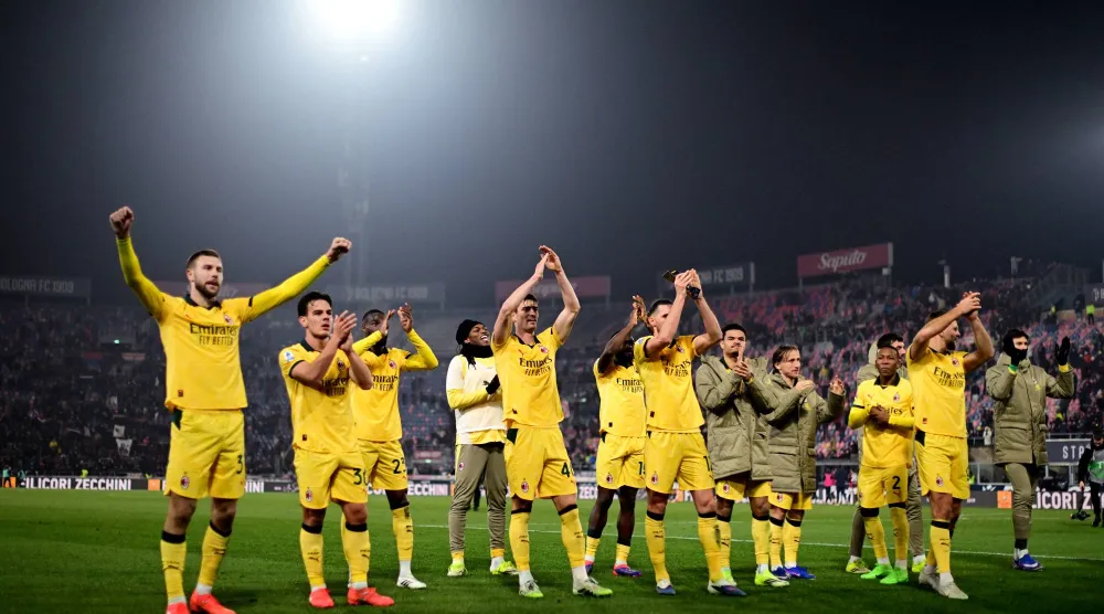 لاعبو ميلان يحيون جماهيرهم الزائرة بعد الفوز على بولونيا في ملعبه (رويترز)