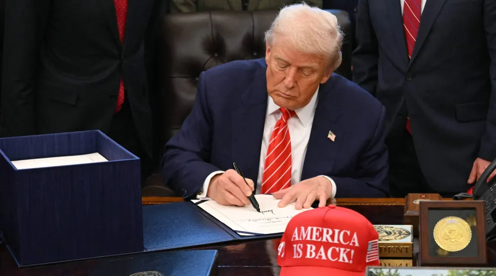 الرئيس الأميركي دونالد ترمب خلال توقيعه على الميزانية الفدرالية في البيت الأبيض (أ.ف.ب)