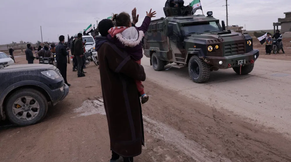 استقبال أهالي القامشلي لقوات الأمن الداخلي التابعة للحكومة السورية التي تستعد لدخول المدينة شمال شرقي سوريا من تل براك قرب الحسكة الثلاثاء (رويترز)