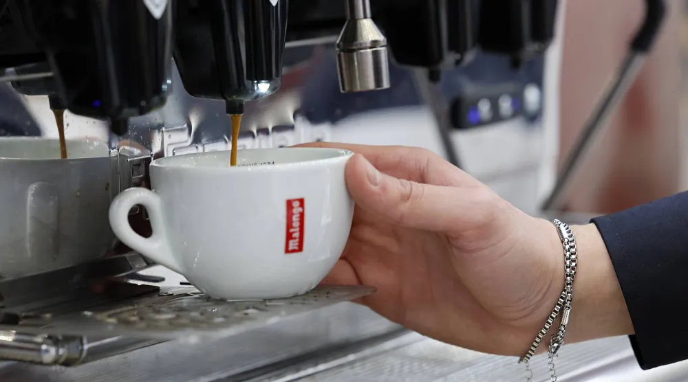 سيدة تحضر كوباً من القهوة في مدينة نيس الفرنسية (إ.ب.أ)