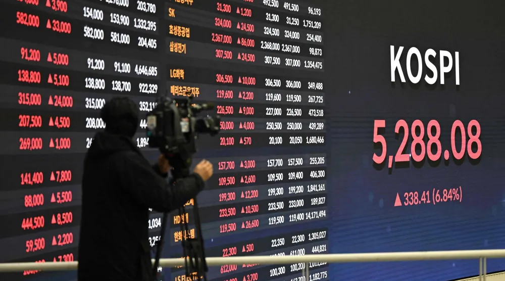 مصور يوثّق شاشة تعرض مؤشر «كوسبي» في بورصة سيول (أ.ف.ب)