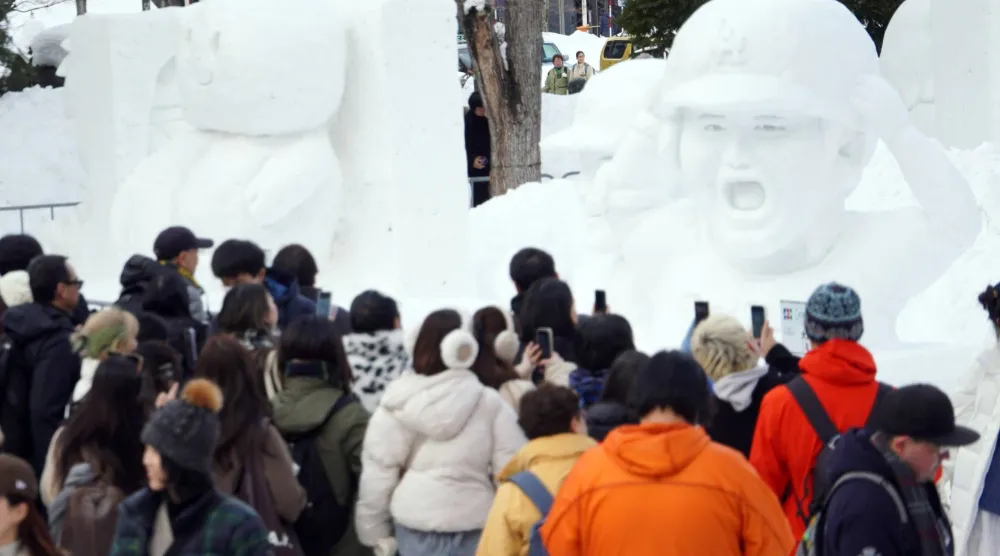 مواطنون وسواح يشاهدون منحوتات في معرض الجليد السنوي شمال اليابان (إ.ب.أ)