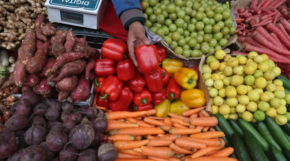 بائع يمسك بحبة من الفلفل الأحمر في الهند (إ.ب.أ)