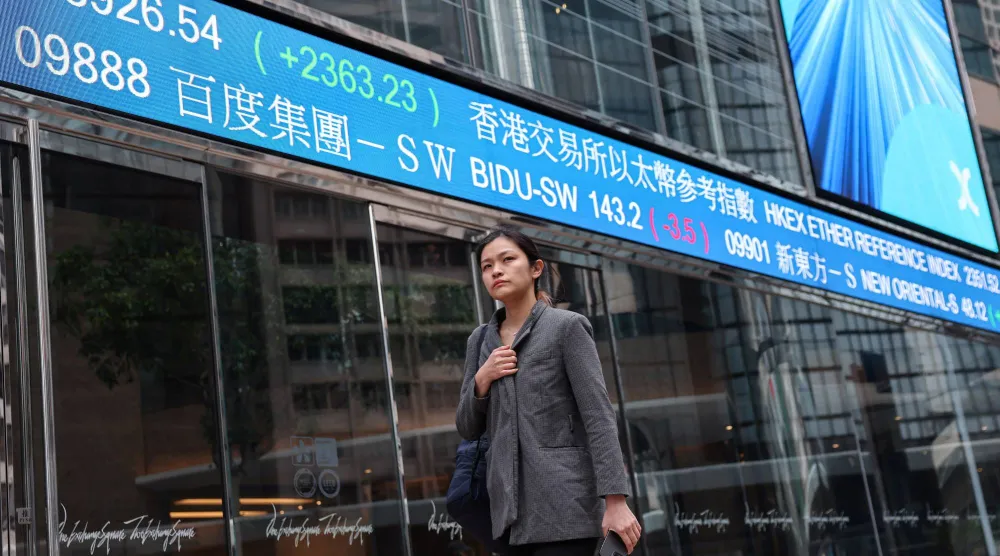 شاشة تعرض حركة الأسهم في الضاحية المالية بجزيرة هونغ كونغ الصينية (رويترز)