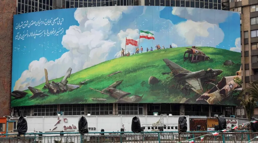 لافتة دعائية معادية للولايات المتحدة معلقة في ميدان ولي عصر وسط طهران الخميس (أ.ف.ب)