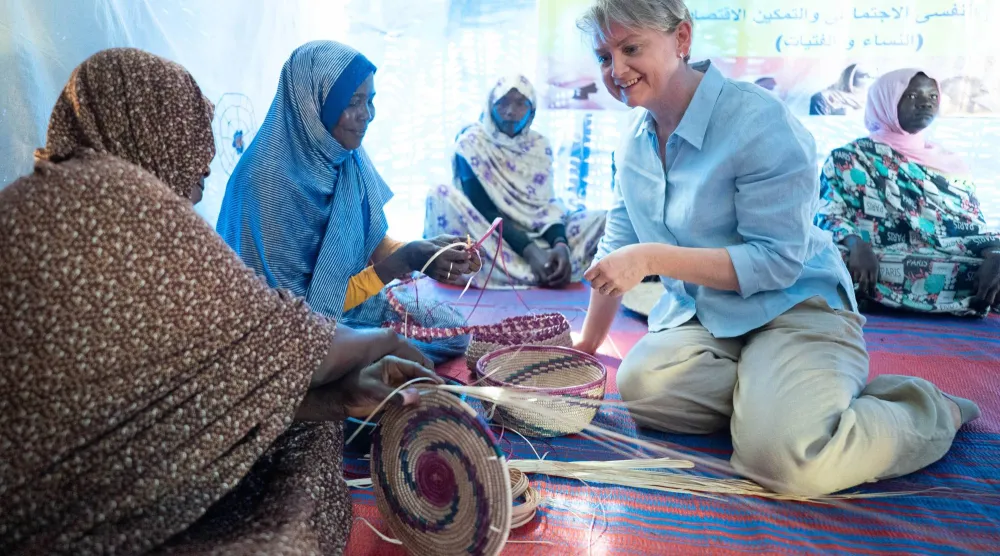 وزيرة الخارجية البريطانية إيفيت كوبر تتحدث إلى نازحات سودانيات في بلدة أدري التشادية يوم 3 فبراير (د.ب.أ)