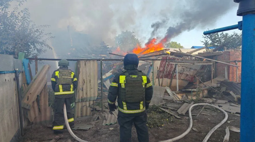 أرشيفية لرجال إطفاء يعملون خارج مبان اشتعلت فيها النيران جراء القصف في بيلغورود (رويترز)