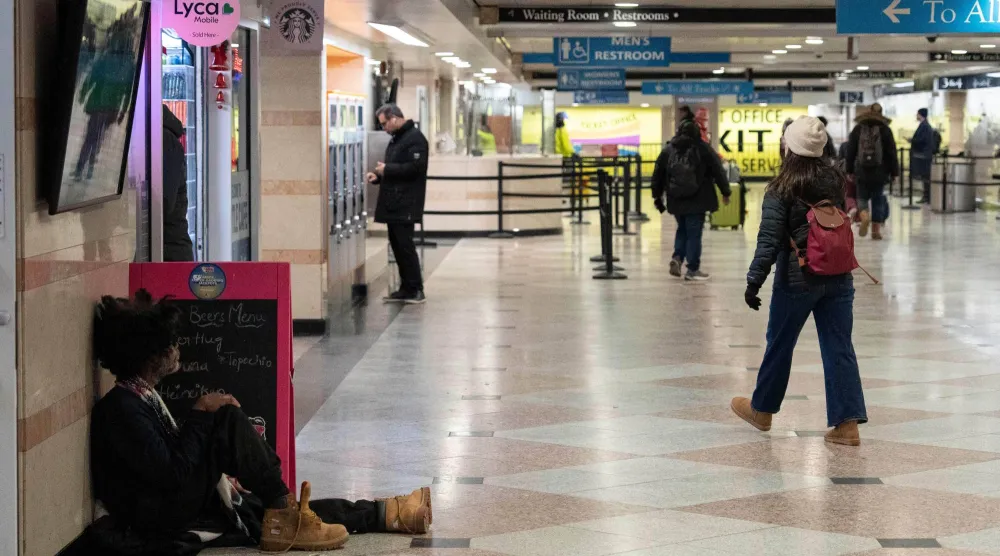 شخص يجلس على أرضية «محطة بن» في نيويورك (أ.ب)