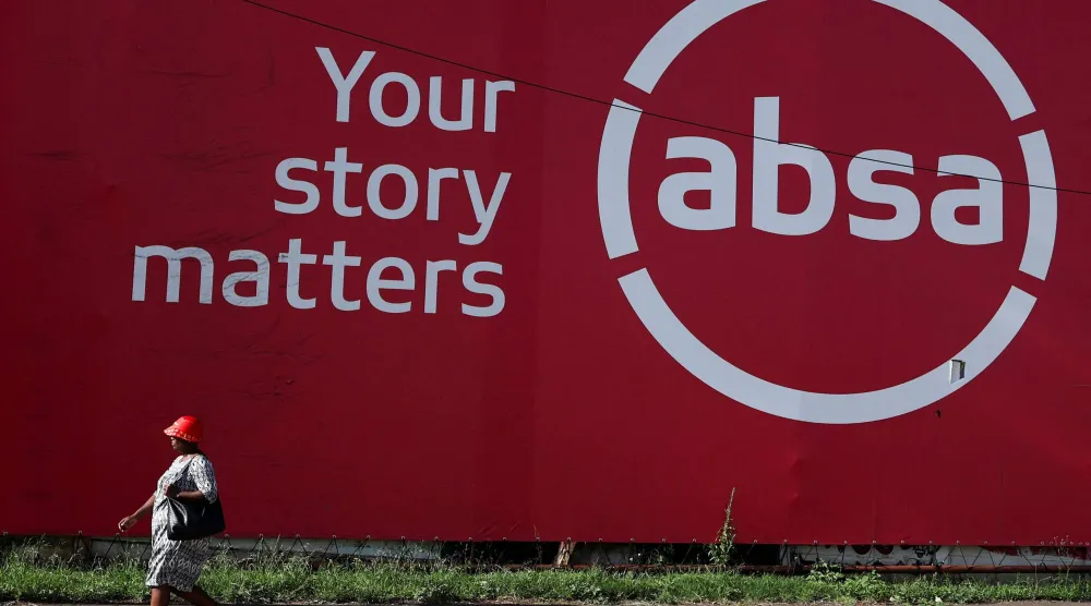 رجل يمر أمام مقر أحد البنوك المحلية في مدينة سويتو بجنوب أفريقيا (رويترز)