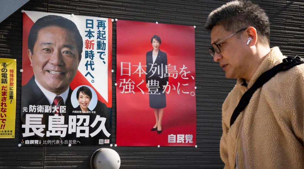 رجل يمر أمام لافتات انتخابية وسط العاصمة اليابانية طوكيو (أ.ف.ب)